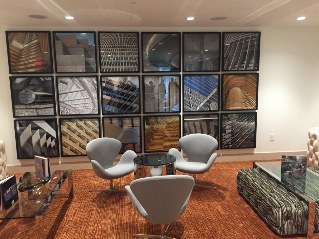 A Hotel Indigo seating area with a wall of photos of Portman signature designs.